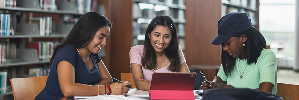 Three female students studying in the library