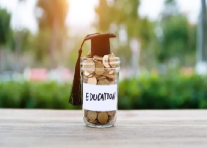 jar of coins labeled "education" with graduation cap on top 